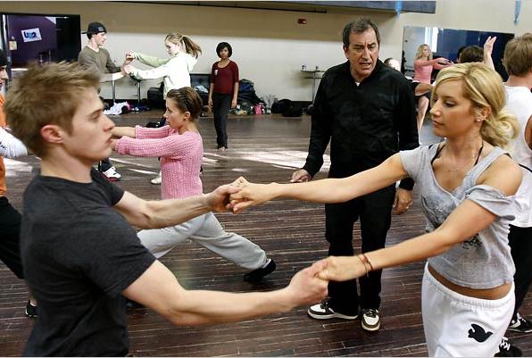 O diretor Kenny ortega ensaioa elenco de "High School Musical". Na frente, os atores Lucas Grabeel e Ashley Tisdale, que vivem os irmãos Evans